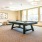 a room with a pool table and a large window